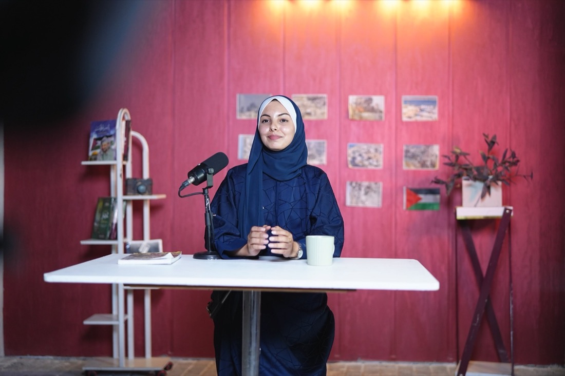 المقدّمة على الطاولة، والميكروفون في مكانه، والجدار خلفها يروي الحكاية.